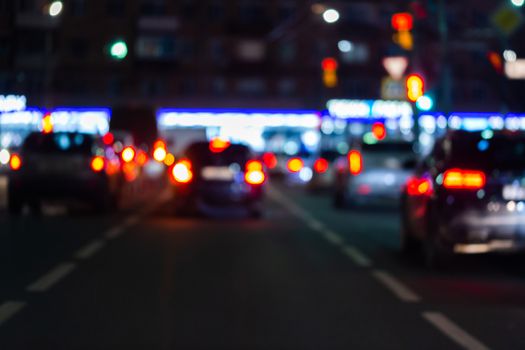 Defocused picture of night street car traffic - view from road. Colorful night life dark background.