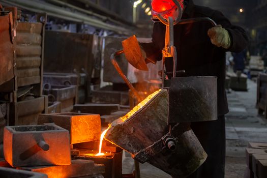 Industrial chill casting. The process of for filling out mold with molten metal from ladle.