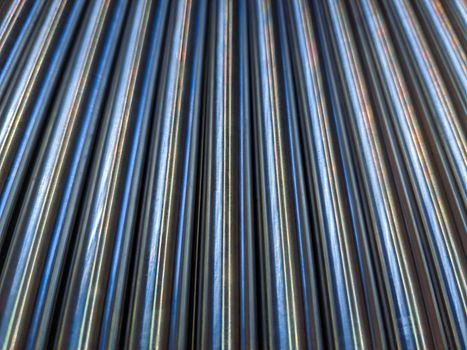 a simple abstract industrial close-up background of shiny cnc turned rods with linear perspective and selective focus