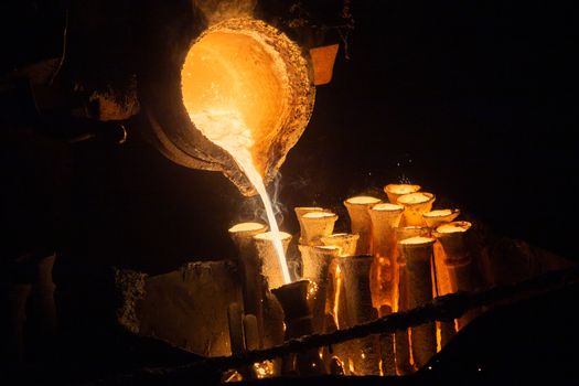 Industrial lost wax casting. The process of pouring for filling out ceramic shells with molten steel from ladle.