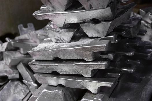 messy stack of aluminium ingots - close-up with selective focus,