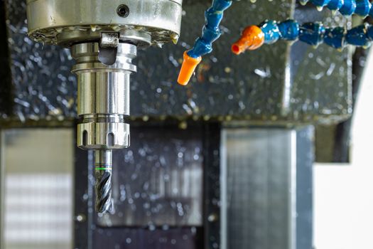 wet carbide mill and collet chuck in vertical cnc milling machine with blue plastic hose system for coolants and air