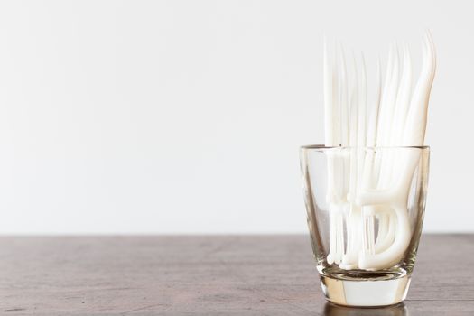 Oral Device : Dental floss in glass on wooden background