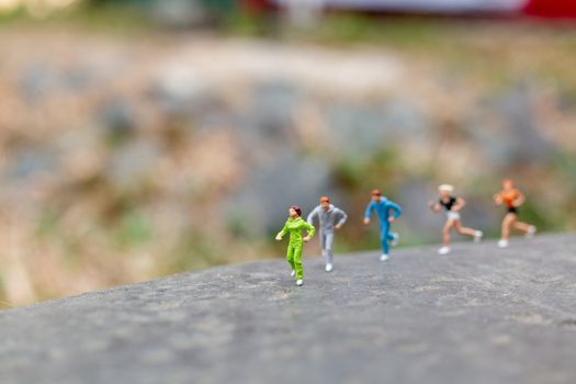 Miniature people Running on The Rock , Health And lifestyle concepts.