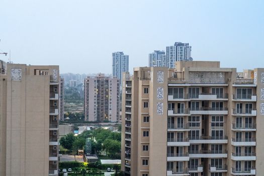 Aerial dusk shot of buuldings with warm orange lights shining out of the newly constructed homes offices and residences . Shows the elegance and opulence of the real estate sector in cities like Gurgaon, Mumbai, Jaipur, bangalore, mumbai and more