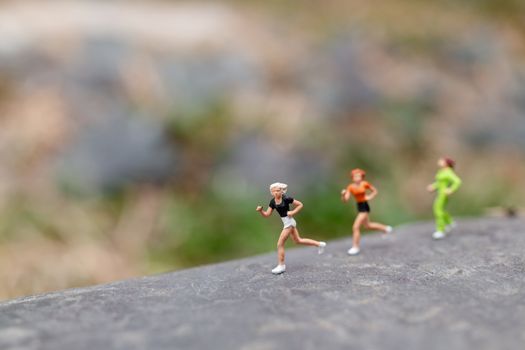 Miniature people Running on The Rock , Health And lifestyle concepts.