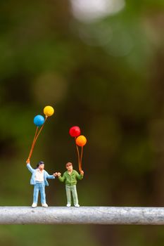 Miniature people : Happy family  holding colorful balloons ,   Happy family  Concept