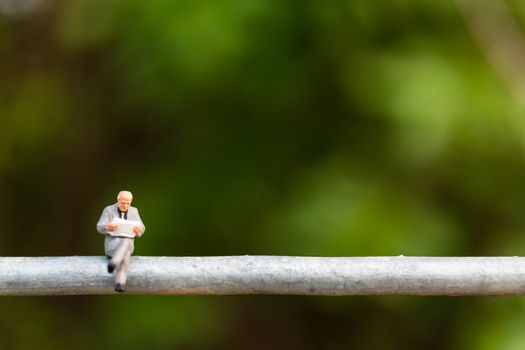 Miniature people : business people sitting on a  wire with green background 
, Business  team concepts