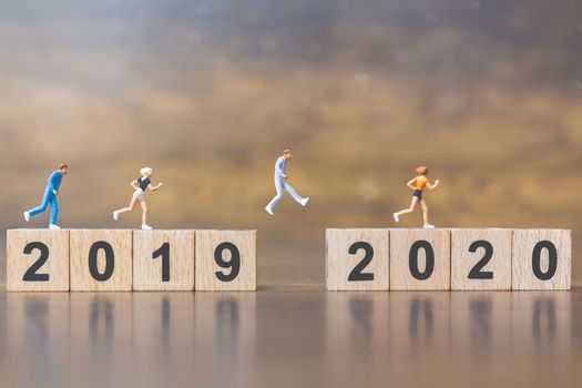 Miniature people Jump from number 2019 to number 2020 , Happy new year concepts.