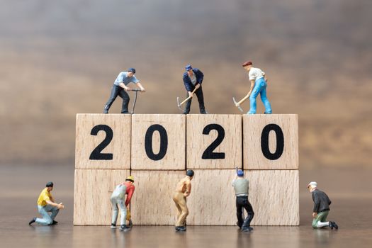 Miniature people : Worker team create wooden block number 2020  , Happy new year concept