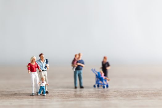 Miniature people : Parents with children walking outdoor , Happy family concept