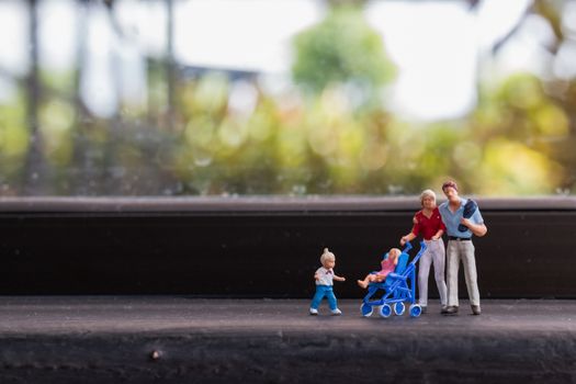 Miniature people : Parents with children walking outdoor , Happy family concept