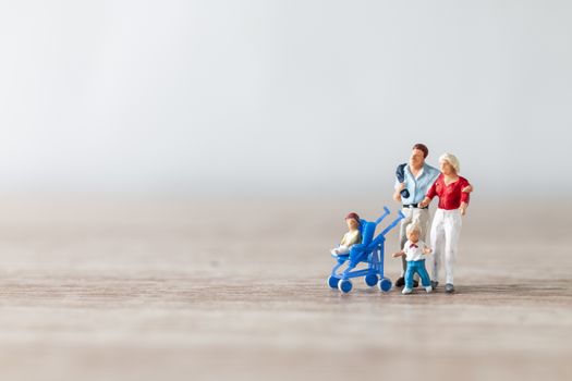 Miniature people : Parents with children walking outdoor , Happy family concept