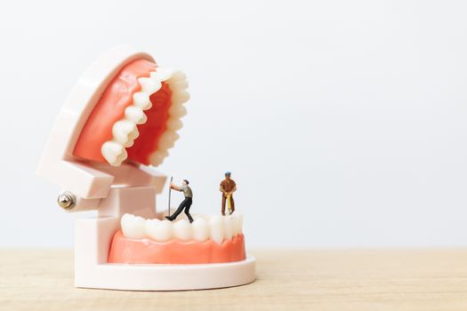 Miniature people : Worker team repairing a tooth ,Healthcare and medical concept