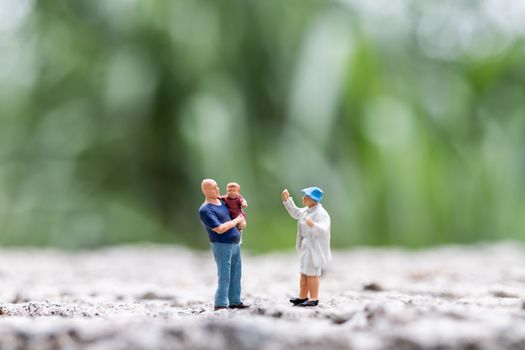 Miniature people : Parents with children walking outdoor , Happy family concept