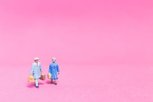 Miniature people : Couple of travellers on pink background , Valentine's day concept