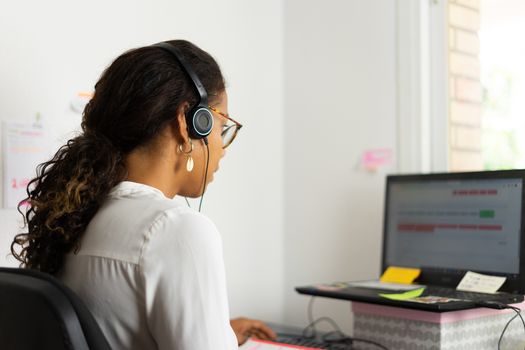 Working brazilian young woman in bedroom. Telemeeting. Video conference. Remote work. Call center home.