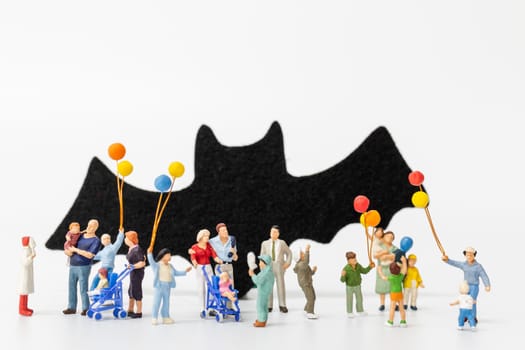 Miniature people:  Happy family holding balloon on white background Happy Halloween concept