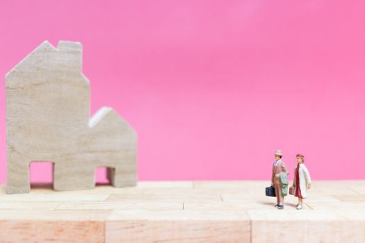 Miniature people : Couple with house on pink background , Valentine's day concept