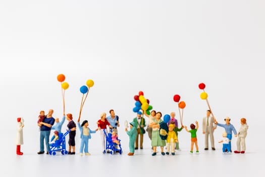 Miniature people holding balloon isolated on white background and copy space for text