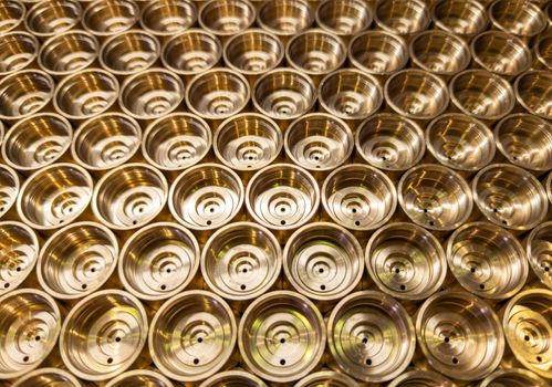 an abstract perspective industrial close-up background of shiny brass metal threaded hexagonal fitting parts.