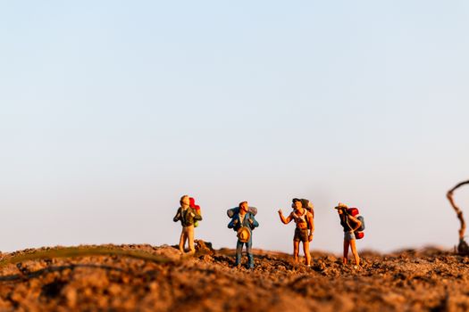 Miniature people : Traveler with backpack mountaineering. Hiking man with backpack walking outdoor