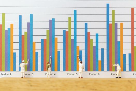 Miniature people : Worker painting business graph on white background , Business growth concept
