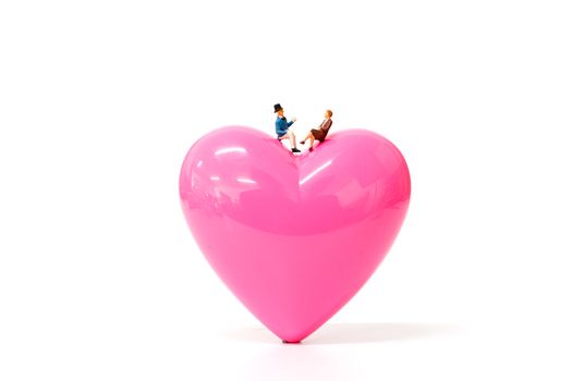Miniature people  couple with  pink heart on white  background , Valentine's Day concept