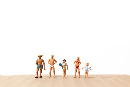 Miniature people wearing swimsuit standing on the beach  , vacation concept