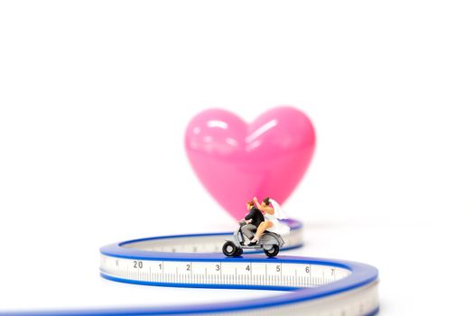 Miniature people : Couple in love riding a motorbike ,Valentine's Day concept.