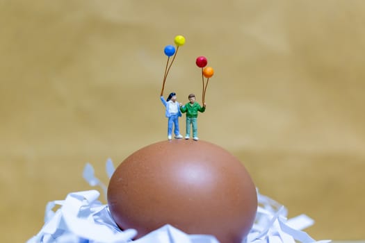 Miniature people : Happy family holding balloon celebrating Easter eggs