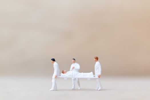Miniature people : Doctor with nurse carry the patient on a stretcher. Healthcare  concept.