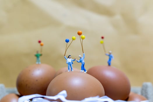 Miniature people : Happy family holding balloon celebrating Easter eggs