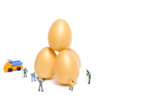 Miniature people work at Easter-eggs for Easter day on white background