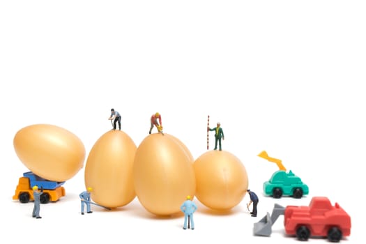 Miniature people work at Easter-eggs for Easter day on white background