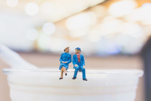 Miniature people : Couple sitting on cup , Valentine day's concept