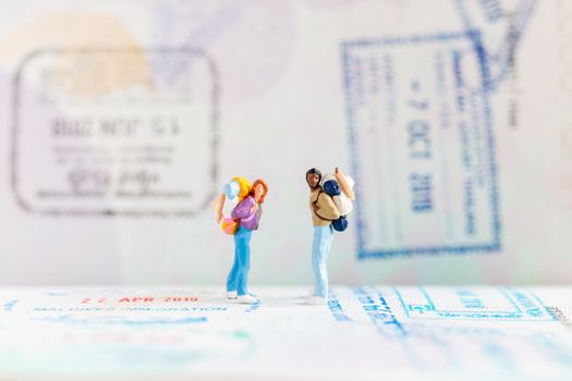 Miniature people : Traveler with backpack walking on Passport , Travel and Adventure concepts.