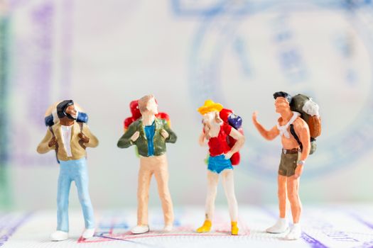 Miniature people : Traveler with backpack walking on Passport , Travel and Adventure concepts.