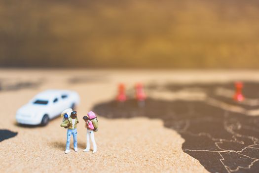 Miniature people travelers walking on world map , Traveling and exploring the world Concept