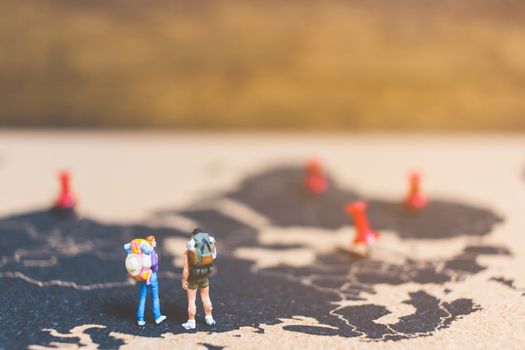 Miniature people travelers walking on world map , Traveling and exploring the world Concept