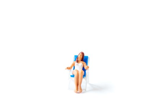 Miniature people sunbathing on deck chairs on white background , Summer time concept