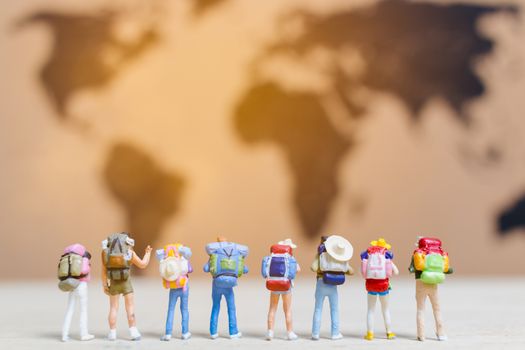 Miniature people travelers walking on world map , Traveling and exploring the world Concept