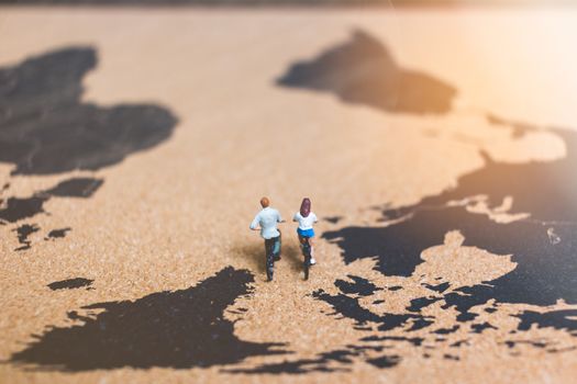 Miniature people travelers riding bicycle on world map , Traveling and exploring the world Concept