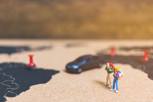 Miniature people travelers walking on world map , Traveling and exploring the world Concept