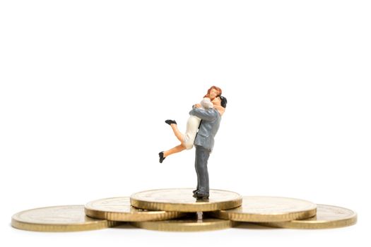 Miniature people: Couple hugging standing on stack of coin , Money and financial concepts.
