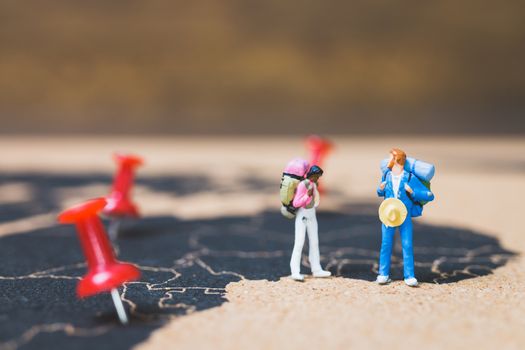 Miniature people backpacker walking on world map, Tourism and travel concept