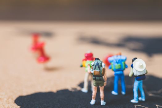 Miniature people backpacker walking on world map, Tourism and travel concept