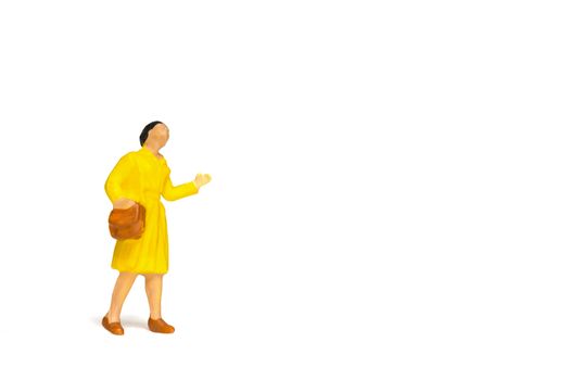 Miniature people ; Traveler holding a handbag standing on white background , Travel concept