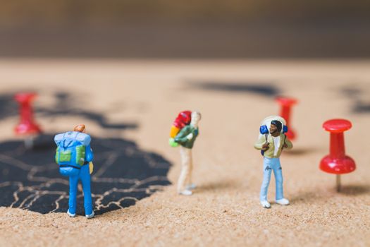 Miniature people backpacker walking on world map, Tourism and travel concept