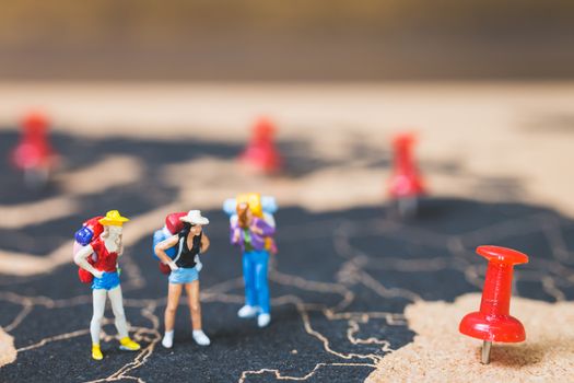 Miniature people backpacker walking on world map, Tourism and travel concept